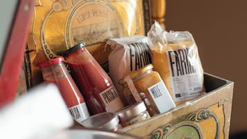 A vintage-style box containing various food items and condiments, with a decorative background including a chandelier and framed pictures.