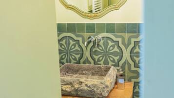 Un bagno con lavandino, specchio e piastrelle decorate.