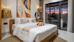 A modern bedroom with a large bed, a view of the sky through a window, and a wall-mounted mirror. - Stella - Luxury Gateaway Villa  (Sayan)
