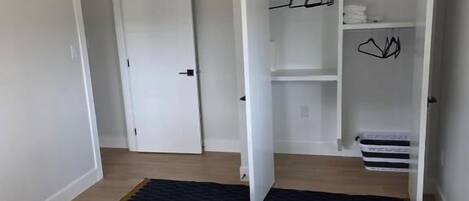Un dormitorio con una cama, un armario y una puerta.