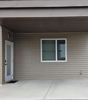 A residential building with a single window, a door, and a small porch area. - Cozy Irvine Creek Walk-out Suite 10 Mins to YEG (Leduc County)