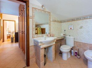 A bathroom with a sink, toilet, and bidet, a mirror, and a shower area. - Ma Vero Residence (Medulin)