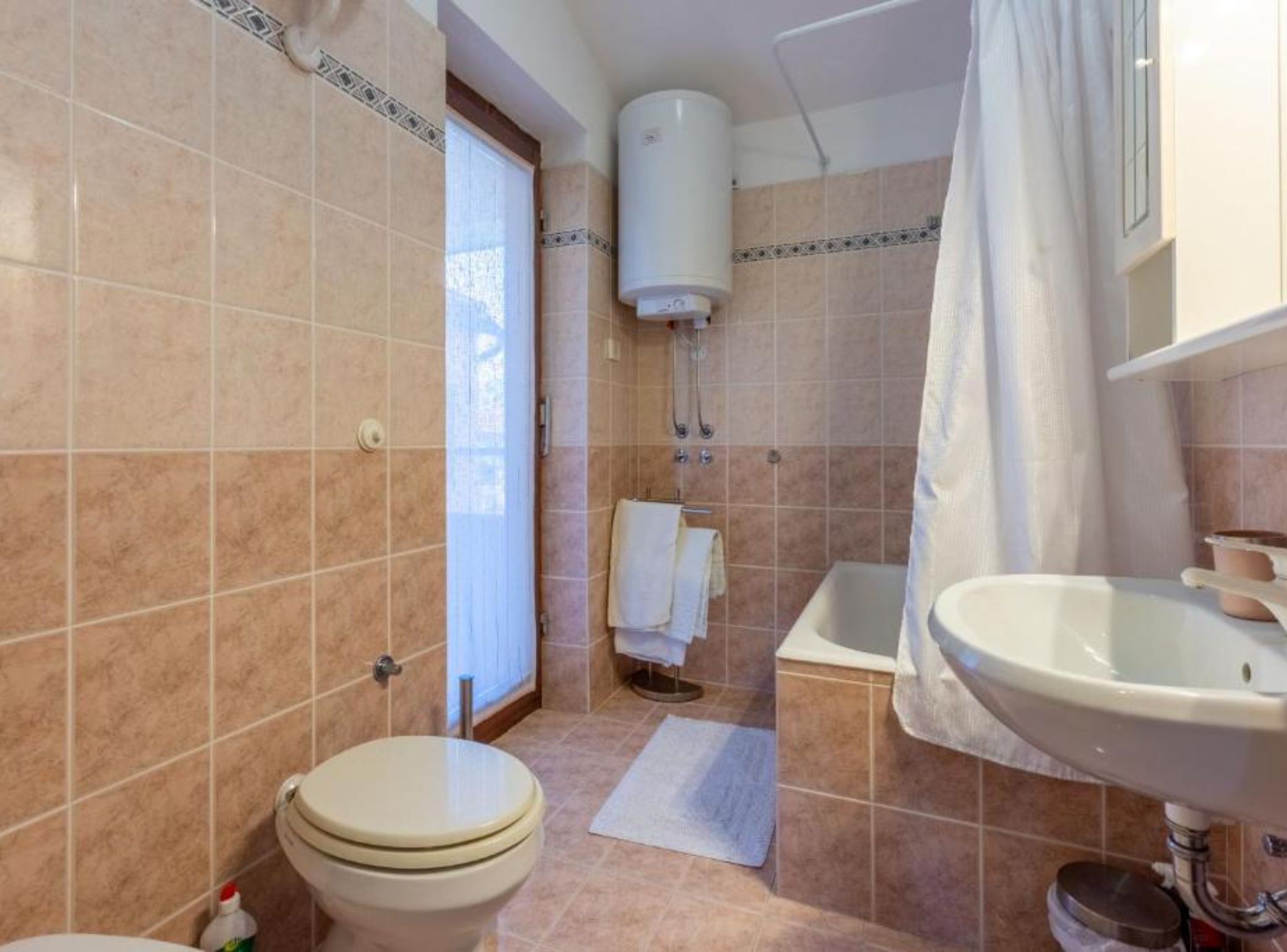 A bathroom with a toilet, bathtub, and sink.