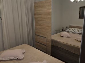 Une chambre à coucher avec un lit, une table de chevet, une lampe et un miroir.