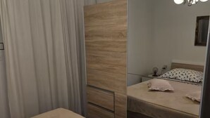 A bedroom with a bed, a nightstand, a lamp, and a mirror. - Villa Solea (Hvar)