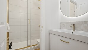 A bathroom with a shower, toilet, sink, and mirror. - New: The Tetbury Suite · 2-bed luxury apt (Tetbury)
