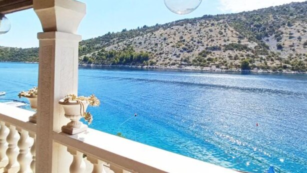 A balcony with a view of a large body of water and a hilly landscape. - Villa Bonaca (Marina)