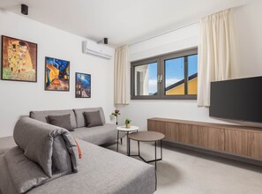 Appartement (Classic Apartment with Balcony) | Woonkamer | Een 32-inch flatscreentelevisie met satellietzenders