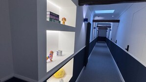Un pasillo moderno con estantes empotrados que exhiben libros y objetos decorativos.