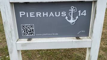 Une enseigne portant l’inscription « PIERHAUS 14 » et un code QR, indiquant le nom d’un hôtel et, éventuellement, son site web.