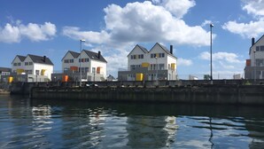 A waterfront property with modern houses, a dock, and a calm water body reflecting the sky. - Nothing Beats the Sea – 2-Bedroom Apartment for 5 with Harbor View in Kappeln (Kappeln)