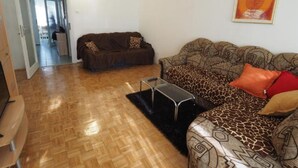 Uma sala de estar com dois sofás, uma mesa de centro e um quadro na parede.