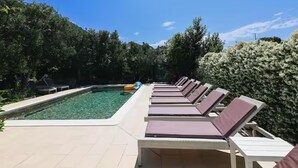 A pool area with lounge chairs and a clear pool. - Deluxe Apartment Marghareta (Dubrovnik)