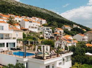 A residential area with hillside buildings, a swimming pool, and a modern building with a balcony. - Residence Apartment Marghareta No. 2 (Dubrovnik)