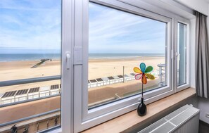 Ein Zimmer mit großem Fenster und Meerblick, einer Windmühle als Dekoration und einer Heizung.