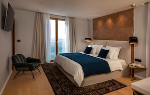 A modern hotel room with a large bed, a desk, a chair, and a TV. - Awesome home in Dubrovnik with sauna (Dubrovnik)