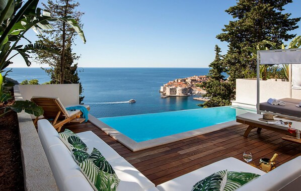 A poolside area with a view of the sea and a historic building. - Awesome home in Dubrovnik with sauna (Dubrovnik)