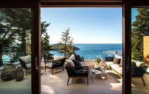 A balcony with seating, a table, and a view of the sea. - Awesome home in Dubrovnik with sauna (Dubrovnik)