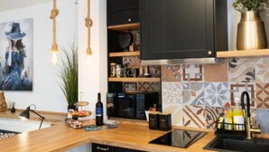 A kitchen with wooden countertops, black cabinets, a hanging light fixture, and a tiled backsplash. - Marghareta Apartment NO 1 - TOP Location (Dubrovnik)