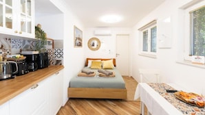 A compact room with a bed, kitchenette, and a window with a WiFi sign. - Marghareta Nest 2 - TOP Location (Dubrovnik)