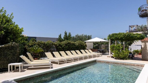 A swimming pool with lounge chairs and a covered area, surrounded by greenery. - Marghareta Nest 2 - TOP Location (Dubrovnik)