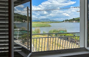 Uma varanda com vista para um lago e montanhas.