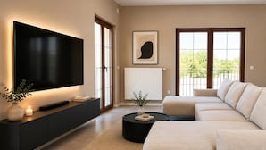 Una sala de estar moderna con un televisor de pantalla plana grande, un sofá, una mesa de centro y un radiador.