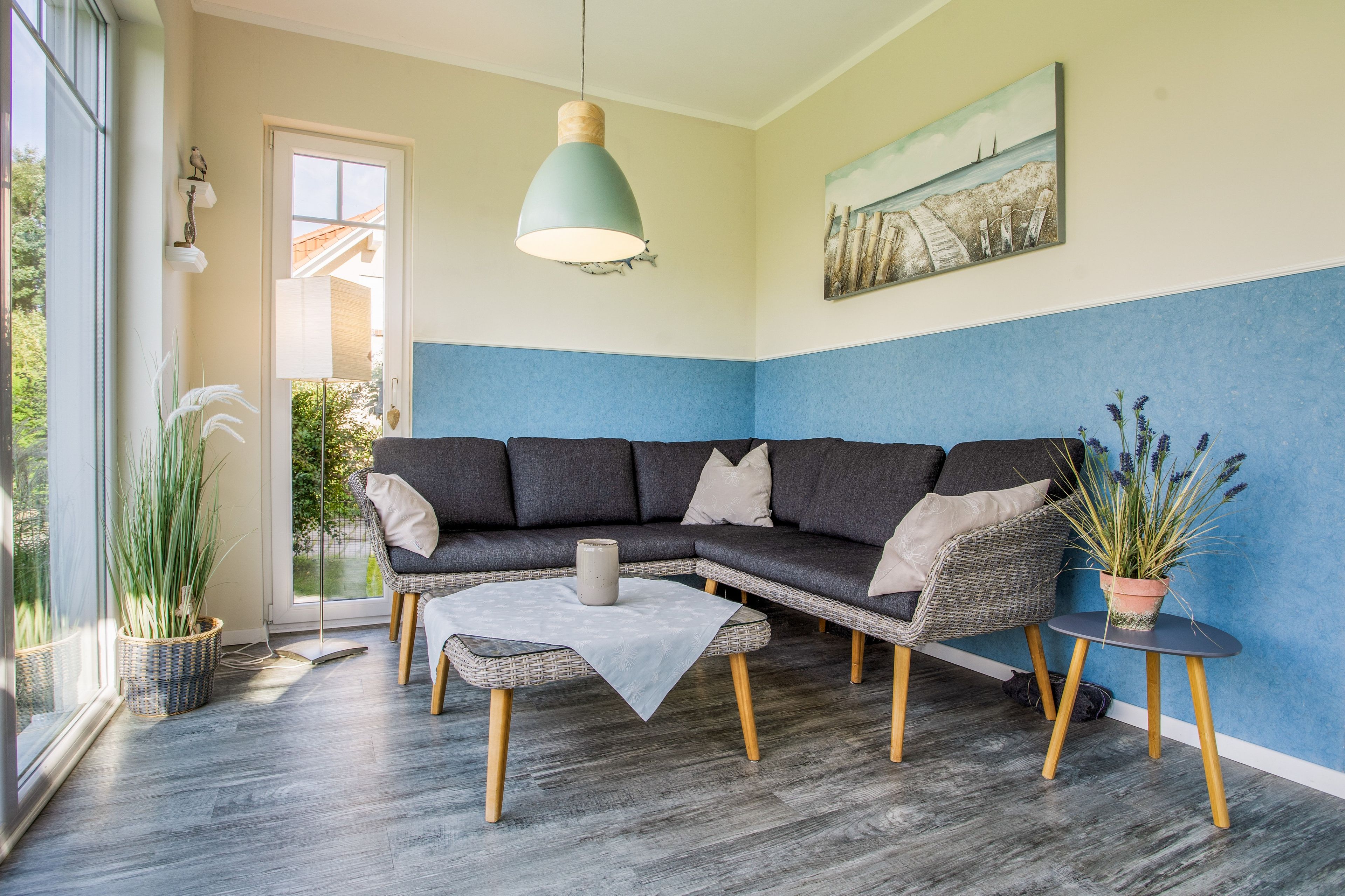 Ein modernes Wohnzimmer mit einem Ecksofa, einem Couchtisch und einer Zimmerpflanze.