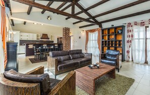 A spacious living area with a dark leather sofa, a wooden coffee table, and a built-in bookshelf. - Luxurious home in Visnjan (Visnjan)