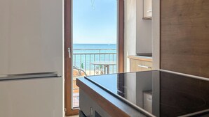 Une cuisine donnant sur la mer, avec une porte ouverte.