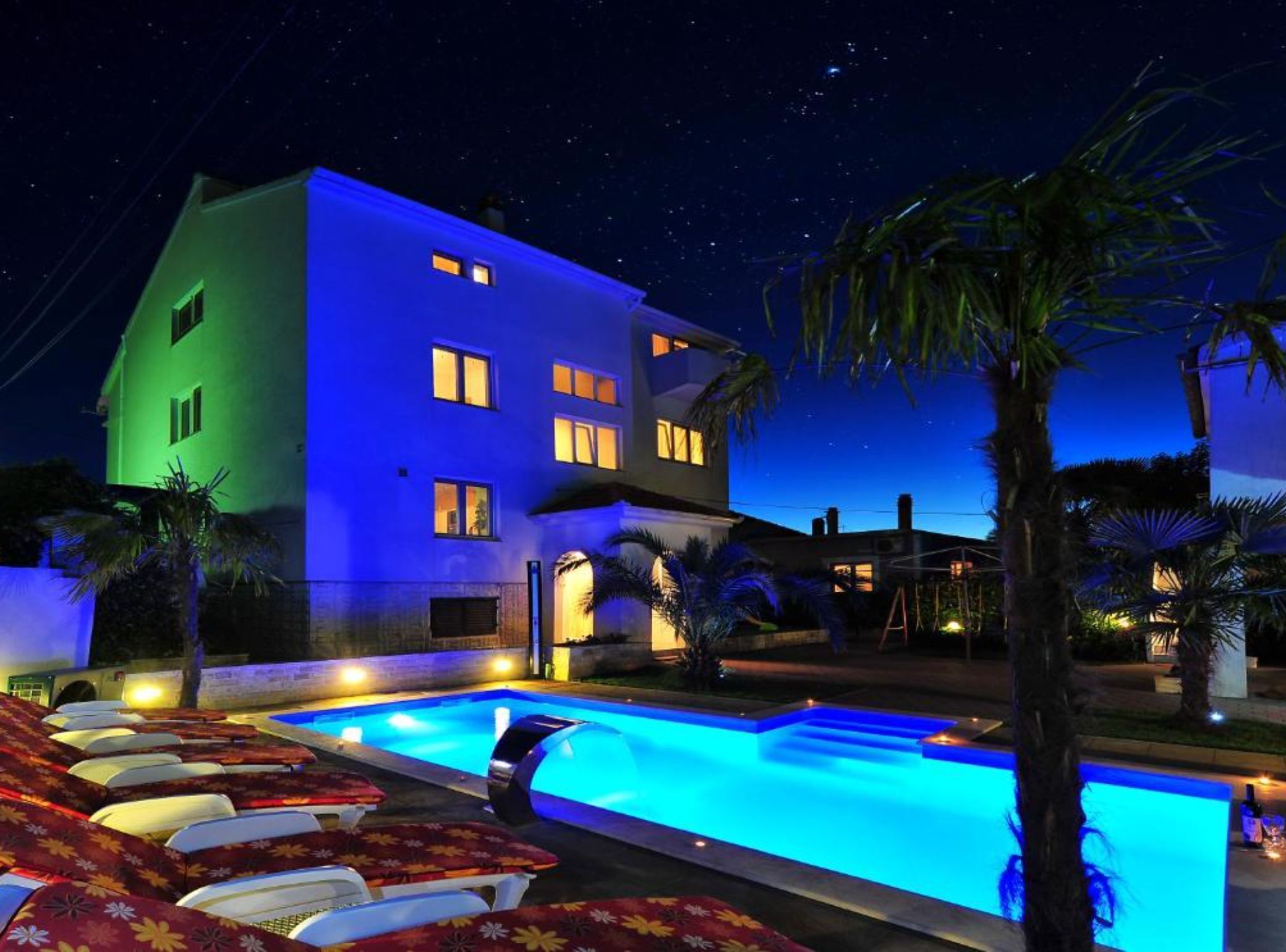 A multi-story hotel with a swimming pool and outdoor seating.