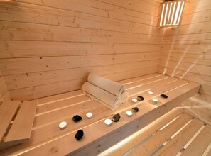 A wooden sauna with benches, a towel, and candles. - Bračić Premium Apartments With Outdoor Pool and Sauna (Sukosan)