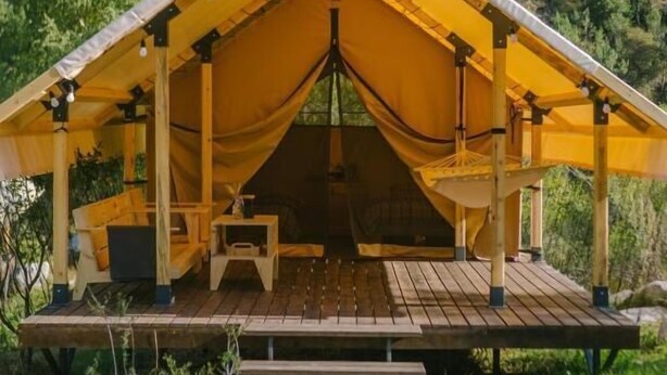 Una estructura con toldo, una terraza de madera y un letrero que dice 'Ayutas'.