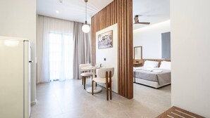 Ein modernes Hotelzimmer mit Essbereich, einem Bett mit Kopfteil und einer Holzwand.