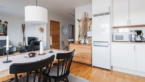 A modern kitchen with white cabinets, a microwave, and a coffee maker. - Olen Village - Funäsdalen (Funäsdalen)