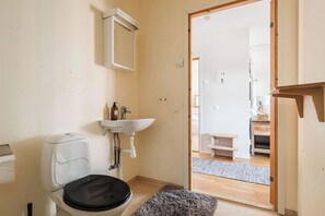 A bathroom with a toilet, sink, and mirror. - Olen Village - Funäsdalen (Funäsdalen)