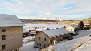 A rural area with wooden buildings, a snow-covered landscape, and mountains in the background. - Olen Village - Funäsdalen (Funäsdalen)