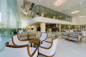 A spacious lobby with modern furniture, a glass atrium, and a visible restaurant named 'BUFFET.'