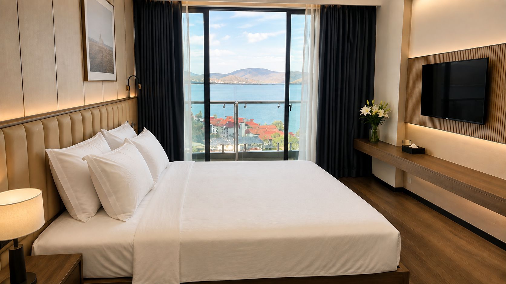 Ein Hotelzimmer mit einem großen Bett, einem Fernseher und Meerblick.