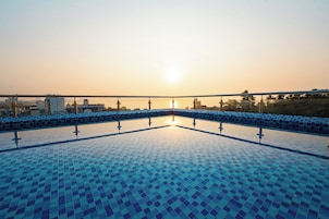 A tiled pool with a clear view of the sky and distant buildings.