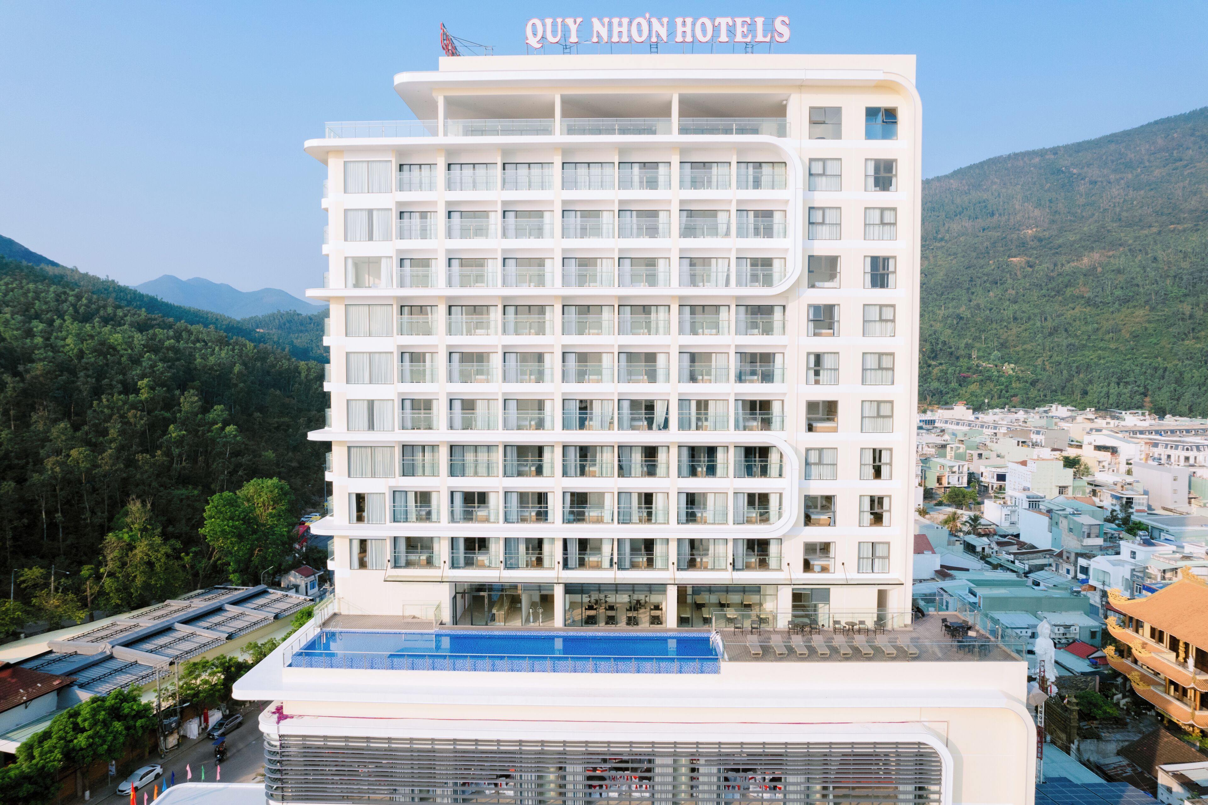 Un hôtel à plusieurs étages offrant une vue dégagée sur le paysage environnant, notamment les montagnes et la ville située en contrebas.