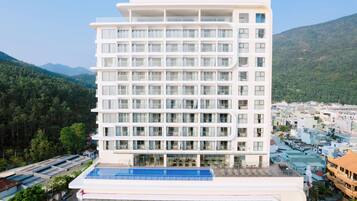 Un hôtel à plusieurs étages offrant une vue dégagée sur le paysage environnant, notamment les montagnes et la ville située en contrebas.