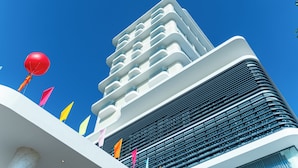 Um edifício moderno com várias varandas e um céu azul claro.