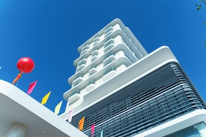 A modern building with multiple balconies and a clear blue sky.