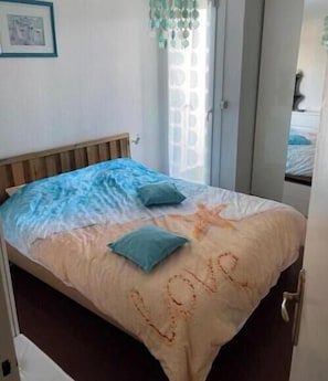 A bed with a starfish design and the word 'love' embroidered on the bedspread. - Apartment F3 Terrace on the port of Carnon 5 minutes from the beach (Mauguio)