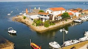 A coastal residential area with houses, a dock, and boats. - Lovely home in Lanton (Lanton)