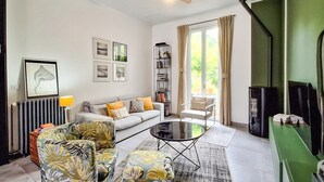 A living room with a sofa, armchairs, a coffee table, a bookshelf, and a fireplace. - Lovely home in Lanton (Lanton)