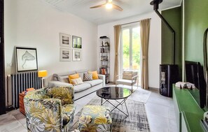 A living room with a sofa, armchairs, a coffee table, a bookshelf, and a fireplace. - Beautiful home in Lanton (Lanton)