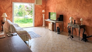 A room with a bed, a desk with a computer, a television, and a fireplace. - 3 bedroom amazing home in Saint-Yvi (Saint-Yvi)