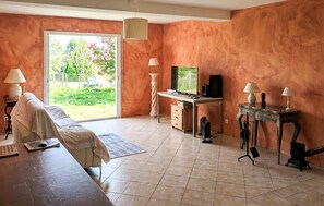 Ein Zimmer mit einem Bett, einem Schreibtisch mit Computer, einem Fernseher und einem Kamin.